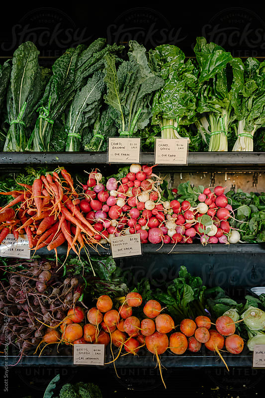 Produce and handwritten price cards at a roadside farm stand